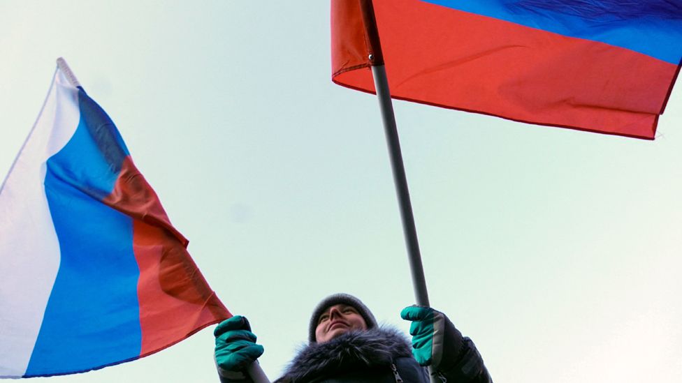 A woman waves Russian flags during a patriotic concert dedicated to the upcoming Defender of the Fatherland Day in Rostov-on-Don on February 22, 2023