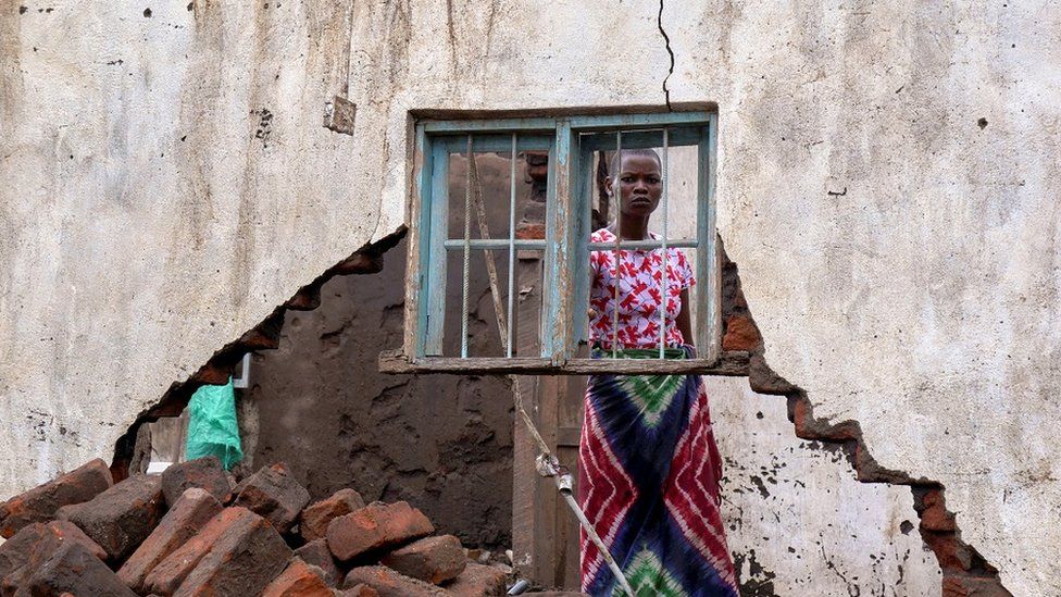 A woman looks on at her house destroyed by tropical storm Ana at Kanjedza village, in Chikwawa district, southern Malawi, January 26, 2022