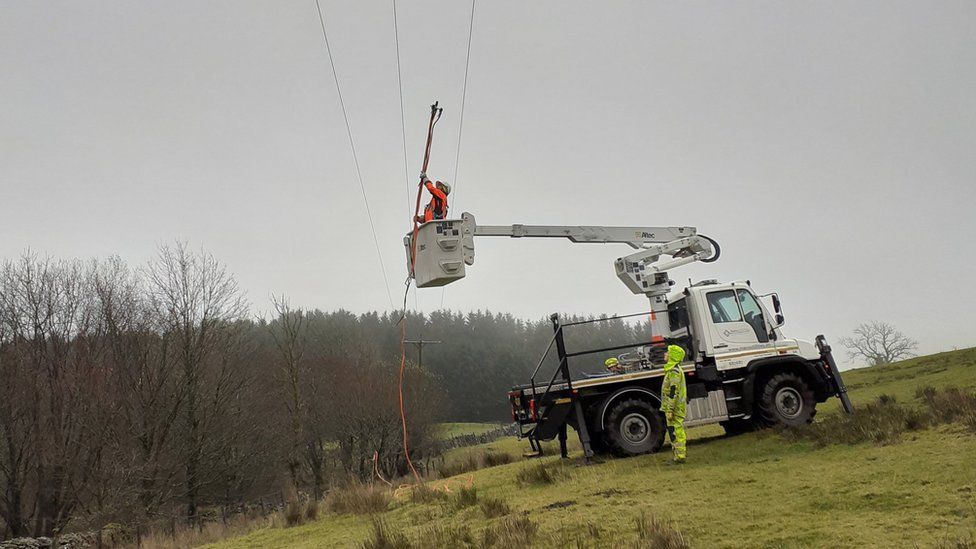 Electricity workers checking overhead power lines
