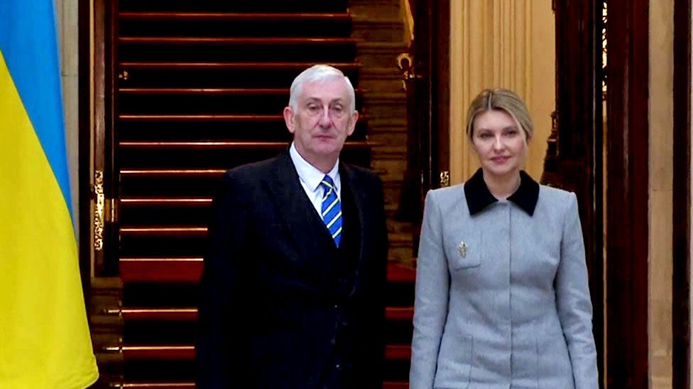Olena Zelenska alongside Speaker Lindsay Hoyle in front of Ukraine and GB flags