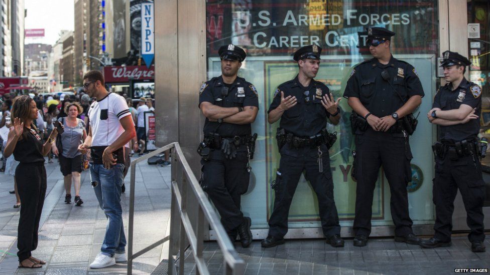 New York City police officers stand guard at a military recruiting centre in Times Square - 16 July 2015