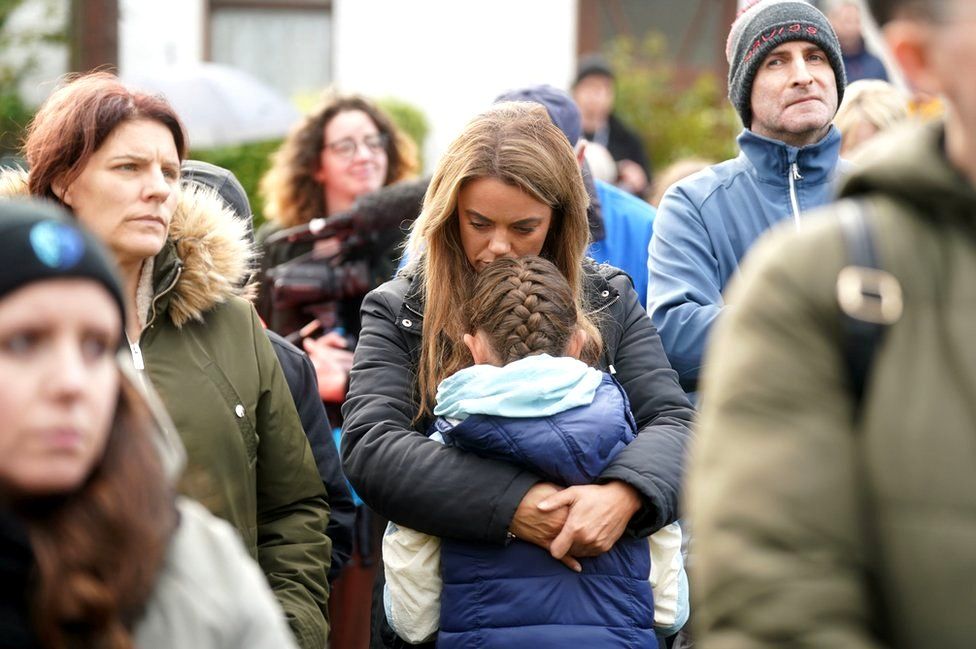 A woman hugs her daughter at a vigil to remember the Creeslough disaster victims in Milford
