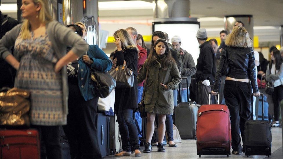 Travellers in a long check-in line at LaGuardia Airport in 2015
