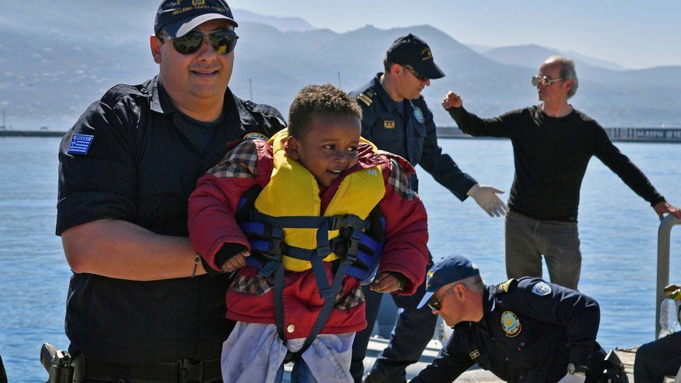 Члены береговой охраны помогают мигрантам высадиться в порту Калмата на Южном Пелопоннесе, Греция, 17 апреля 2016 г.