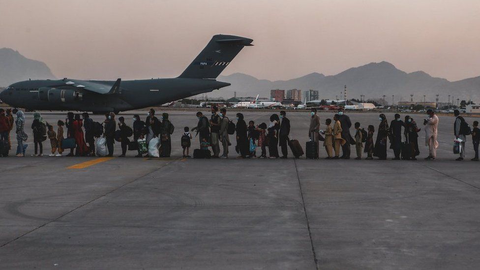 Evacuees wait to board a Boeing C-17 Globemaster