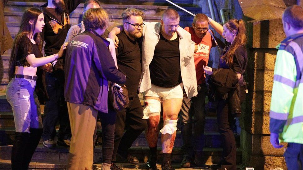 People help an injured man at the Manchester Arena