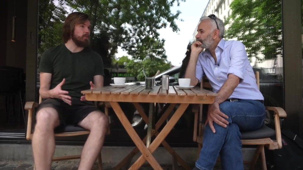 Thomas Kjems (L) speaks to the BBC's Jiyar Gol (R) at a cafe in Copenhagen, Denmark