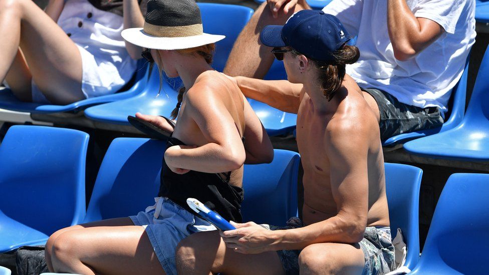 Person applying sun cream to another person