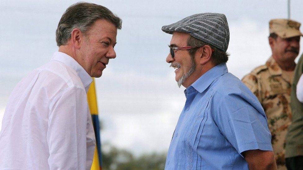 Colombian President Juan Manuel Santos (L) and Revolutionary Armed Forces of Colombia's (FARC) top leader, Rodrigo Londono (R), alias "Timochenko", talk each other during a disarmament ceremony in one of the Farces former military strongholds, Mesetas, Colombia, 27 June 2017