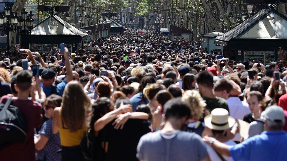 Crowds of people fill Las Ramblas to observe a minutes silence.