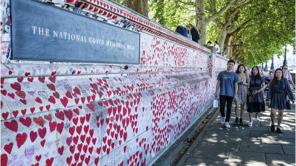 People walk alongside the National Covid Memorial Wall in London