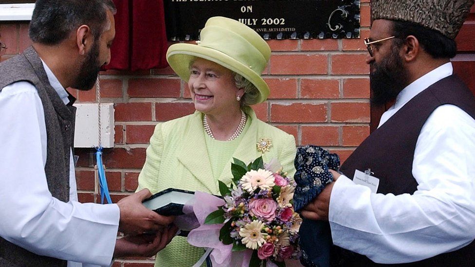 The Queen accepting a Quran during her visit to a mosque in 2002
