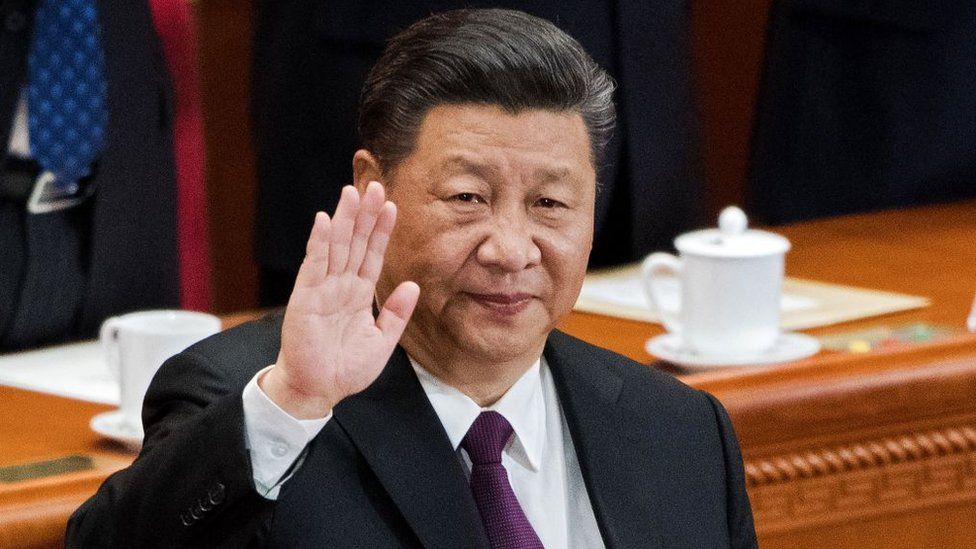 China's President Xi Jinping waves to delegates as he is elected to a second five-year term