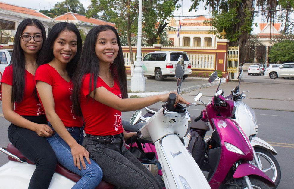 A Cambodian girl is sqeezed between a driver and a passenger of an  overloaded motorbike taxi in the capital Phnom Penh, Tuesday, April 4,  2006. Overloaded motorcycles and cars are a common