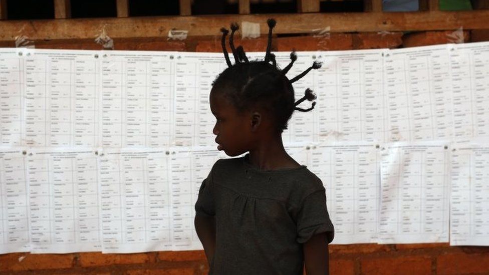 A child stands in front of a voters' list at a polling station in Bangui (14 February 2016)