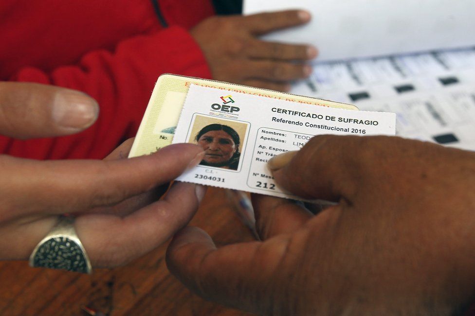 A woman receives a voting certificate in La Paz, 21 February