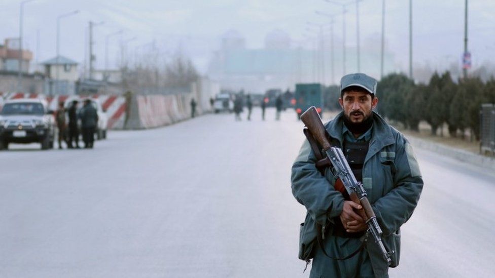 An Afghan security official stands guard outside parliament after twin bombings targeted the building (10 January 2016)