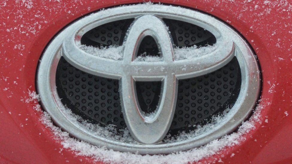 Logo Toyota je vidět na autě Toyota pokrytém sněhem.