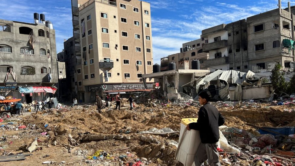 Palestinians inspect damages following an Israeli raid at Kamal Adwan hospital, amid the ongoing conflict between Israel and Palestinian Islamist group Hamas, in the northern Gaza Strip