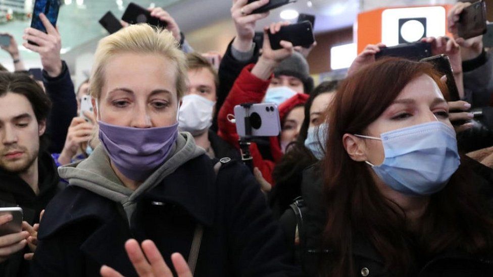 Yulia Navalnaya (front L) and Kira Yarmysh (front R) surrounded by reporters at Moscow Sheremetyevo airport, 17 Jan 21