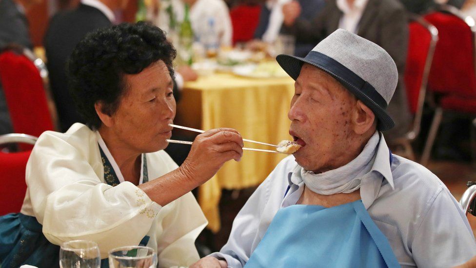 South Korea"s Ahn Jong-ho (R), 100, receives food from his 70-year-old daughter Ahn Jung-soon