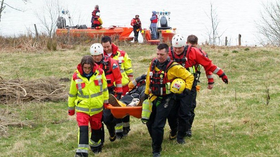Emergency response volunteers carrying a man on a stretcher