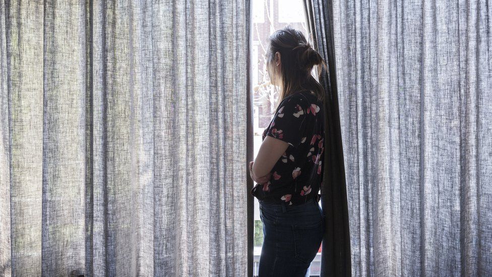 stock photo - woman looking out window