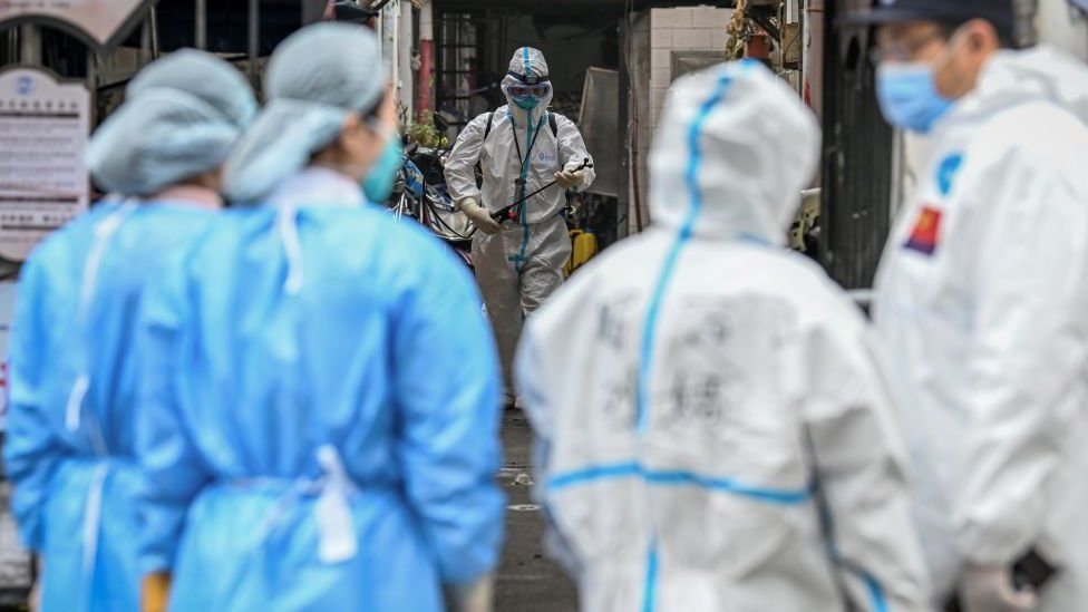 Health workers in protective gear spray disinfectant in a blocked off area in Shanghai's Huangpu district on January 27, 2021
