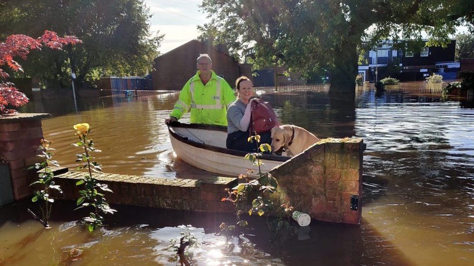 Claire Sandbrook leaving her home in a boat during the October floods