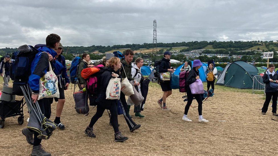 Campers leaving Glastonbury with their belongings