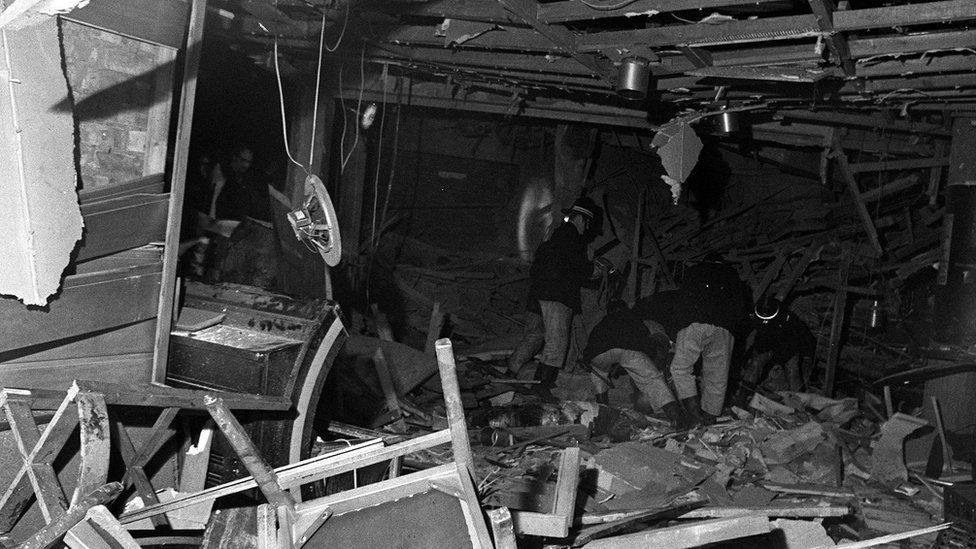 Firefighters search through the wreckage after a bomb went off in Birmingham