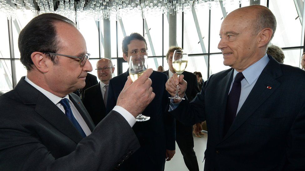 Bordeaux mayor Alain Juppe (R) and French President Francois Hollande (L) raise a toast as French junior minister for Foreign Trade, the Promotion of Tourism and French Nationals Abroad, Matthias Fekl (C) looks on, during the inauguration of the Cite du Vin (Wine Museum) on 31 May 2016 in Bordeaux
