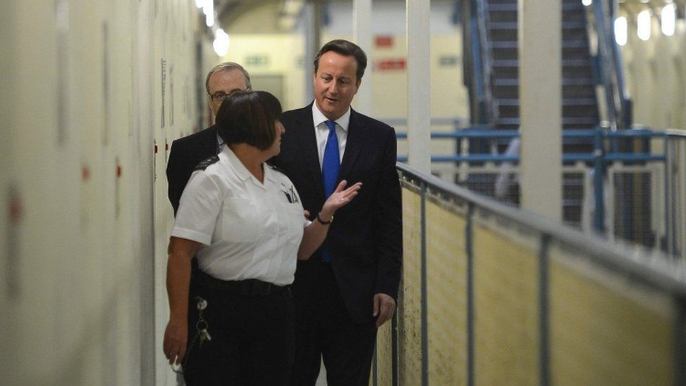 David Cameron being shown round a prison