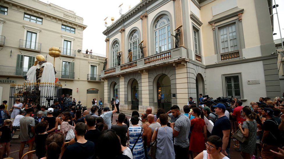 People stand and watch in front of Theater-Museum Dali during the exhumation of Spanish artist Salvador Dali