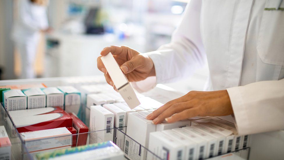 Pharmacist organising the medicine drawer