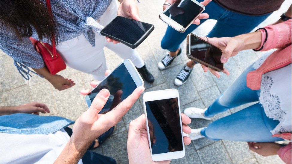 Teenagers holding smartphones