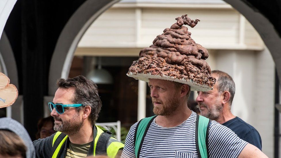 A protestor with a hat made to look like a poo in Bungay, Suffolk