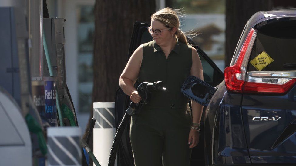 A customer prepares to pump gas into her car at a Chevron gas station on May 20, 2022 in San Rafael, California.