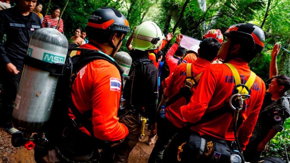 Navy divers assemble in the forest to conduct a search for a group trapped inside a Thai cave