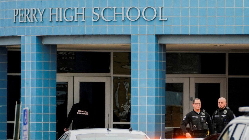 A photo from 4 January shows a medical examiner entering Perry High School as police respond to a school shooting