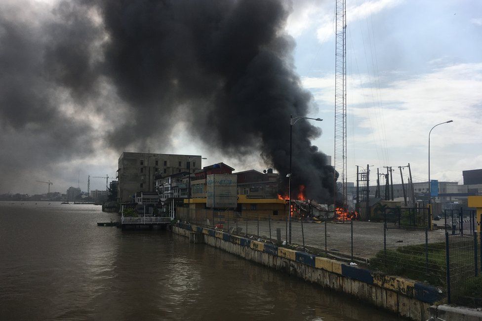 A building on fire next to open water