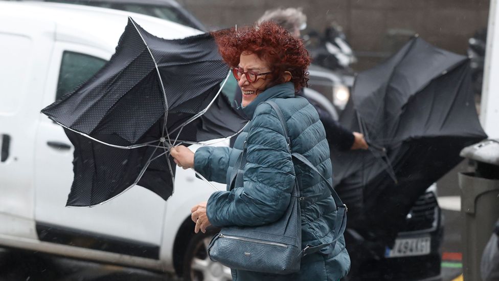 A passer-by holds an umbrella during heavy gusts of wind in a street in downtown Madrid, Spain, 02 November 2023.