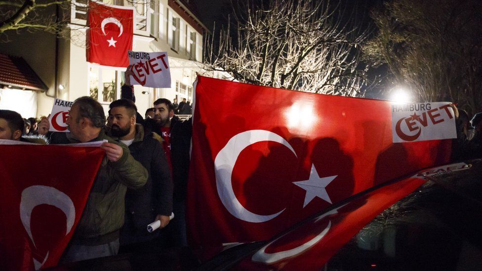 Supporters wave flags as Turkish Foreign Minister Mevlut Cavusoglu emerges from the Turkish consulate in Hamburg, Germany, 7 March 2017