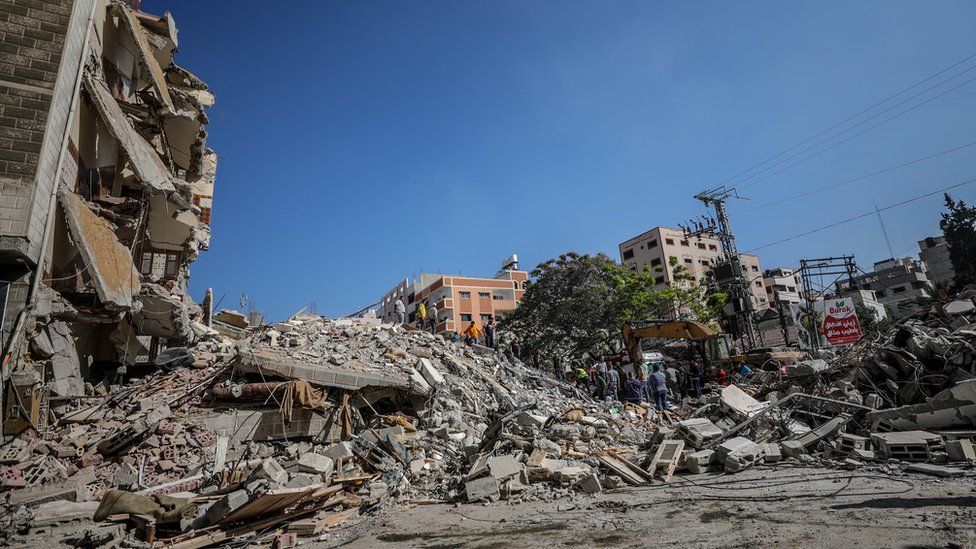 Сотрудники гражданской обороны Палестины ищут людей, оказавшихся под обломками разрушенных зданий в городе Газа (16 мая 2021 г.)