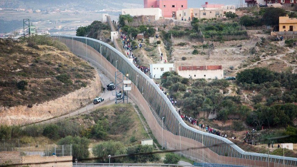 Several people try to reach Spanish soil from the border that separates Melilla and Morocco, 21 May 2021, in Morocco.