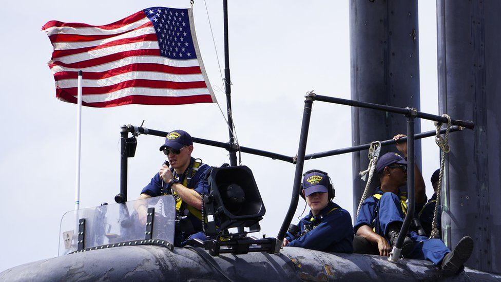 Моряки, назначенные на ударную подводную лодку типа «Лос-Анджелес» USS Albuquerque SSN 706, несут вахту, когда лодка отправляется с острова Диего-Гарсия в 2015 году