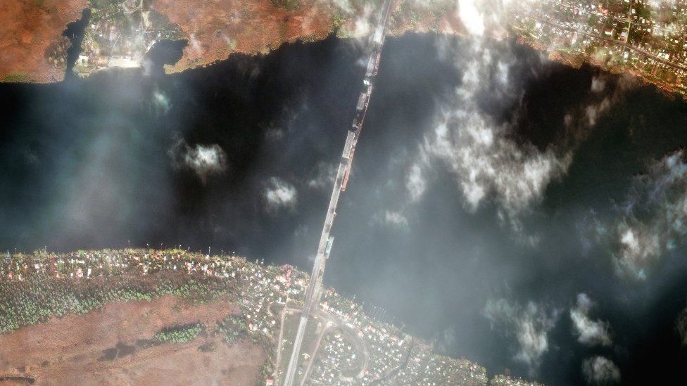 A high-resolution satellite image shows damage to multiple sections of the Antonivsky Bridge