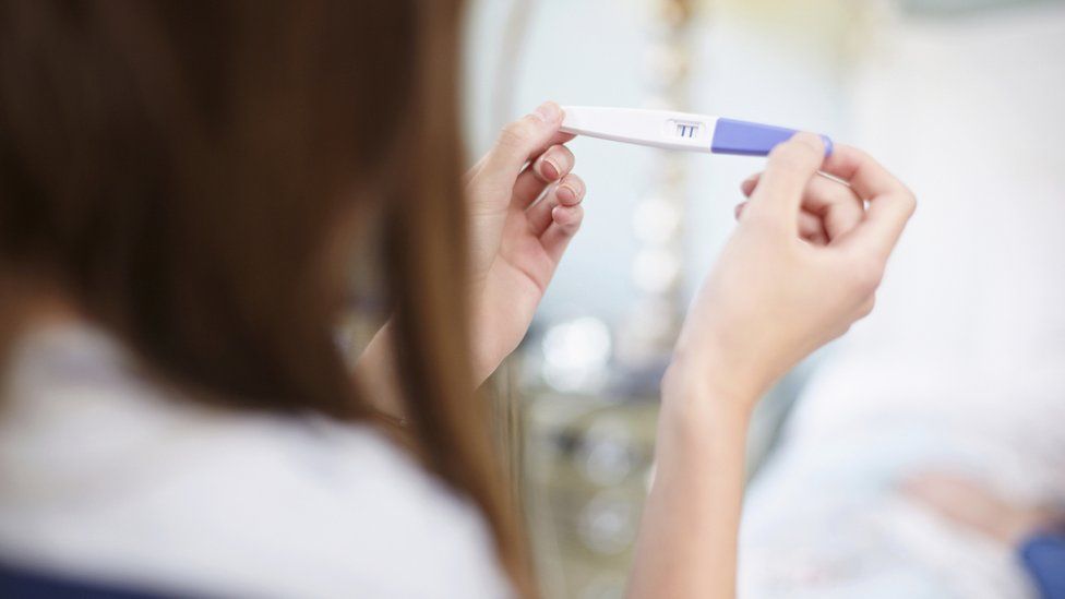 A woman holding a pregnancy test