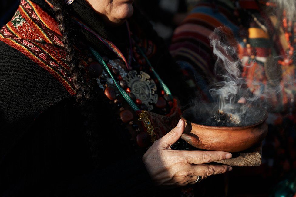 A woman smokes aromatic herbs during a ceremony for Pachamama in Buenos Aires, Argentina, where members of more than 400 indigenous communities arrived after traveling more than 1800 kilometres to protest against the constitutional reform of the governor of Jujuy, on August 1, 2023.