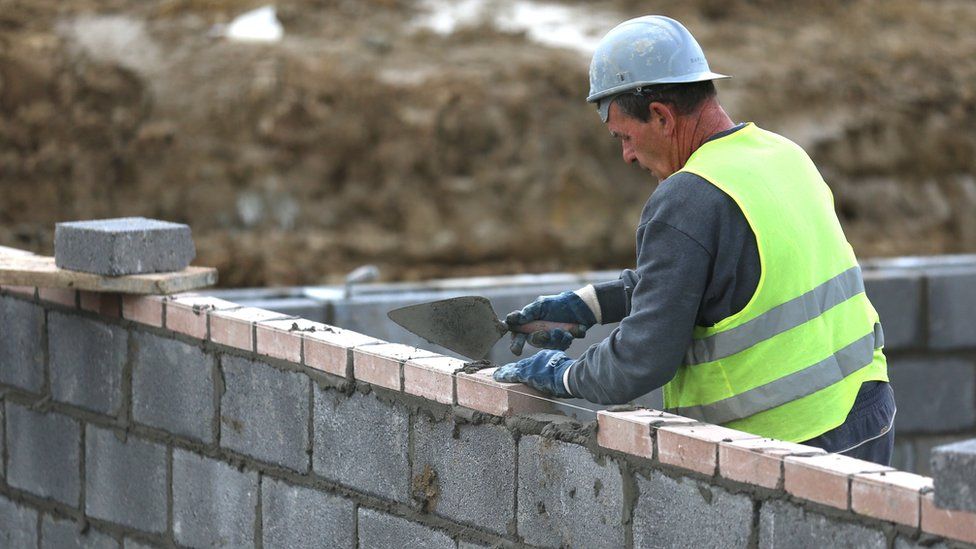 File photo of a construction worker laying bricks at a housing development